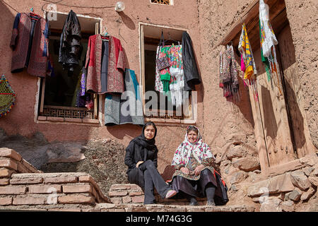 Abyaneh, Iran - 26 Aprile 2017: due donne iraniane in hijabs sedersi nel paesaggio tradizionale in montagna. Foto Stock