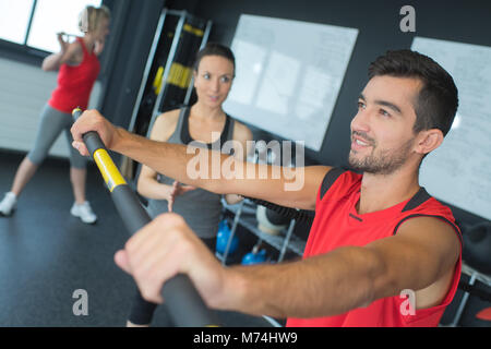 Uomo in palestra di formazione con bastone Foto Stock