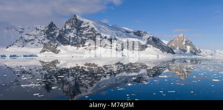 Bellissima scenic Pan Snow capped ghiacciai e scogliere riflette ancora in acque del canale di Lemaire Antartide, Kodiak Gap off la penisola Antartica Foto Stock