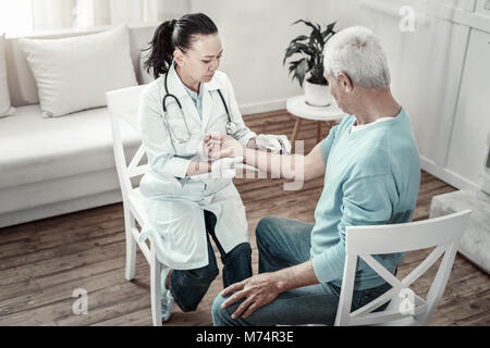 Concentrato infermiera gravi mantenendo la calma e fare l'iniezione. Foto Stock