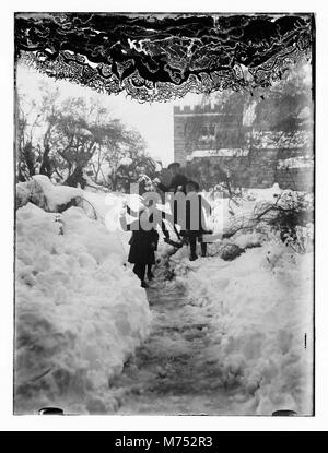 Una fotografia di Gerusalemme coperta di neve, scattata nel 1921. Questa rara scena invernale cattura la città storica con i suoi edifici iconici e le strade coperte di neve, mostrando il contrasto tra l'antica città e il paesaggio innevato. Foto Stock