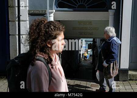 La gente a piedi attraverso Falmouth con navi polena nella distanza. Foto Stock