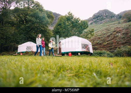 Tre generazioni la famiglia sono ritornando alla loro camping yurt dopo una lunga escursione insieme. Foto Stock