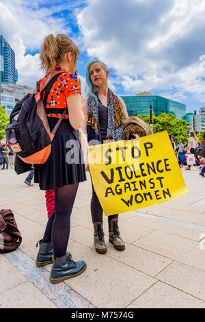 Donna con Stop alla violenza contro le donne segno, , il centro di Vancouver, British Columbia, Canada. Foto Stock