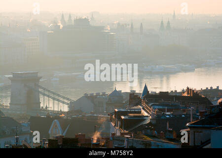 Tetti e campanili di Buda e Pest i lati di Budapest città divisa dal fiume del Danubio nella nebbia Foto Stock