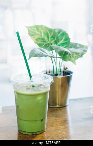 Tè Verde matcha e latte fresco mescolato con ghiaccio in una tazza di plastica al coffee shop in Thailandia pronto a servire i clienti. Iced Green Tea Latte è famou Foto Stock