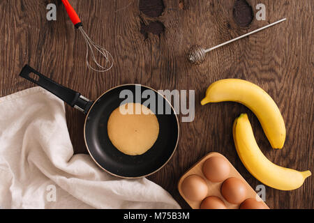 Gli ingredienti per la torta di banane farina uovo su un tavolo di legno. Foto Stock