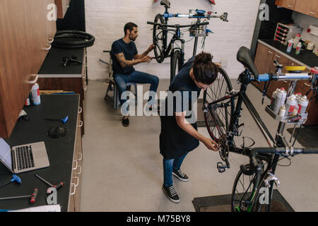 I lavoratori di riparazione di biciclette in un ciclo shop. Meccanica assemblaggio di biciclette in officina. Foto Stock