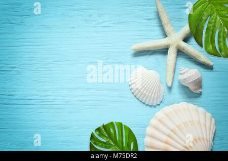 Estate mare sullo sfondo. Stella di mare e conchiglie blu su sfondo di legno. Foto Stock