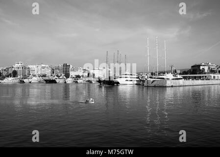 Barca a vela, barche a motore e una piccola barca da pesca attraversando le acque calme nel porto di Marina Zeas .Pireo.Grecia Foto Stock