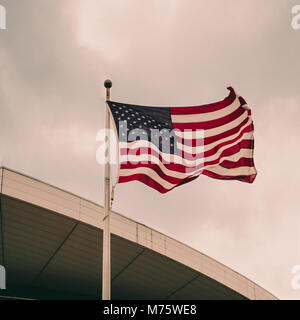 La bandiera americana contro un cielo nuvoloso Foto Stock