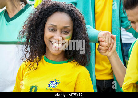Il calcio brasiliano sostenitore sorridendo allegramente, ritratto Foto Stock