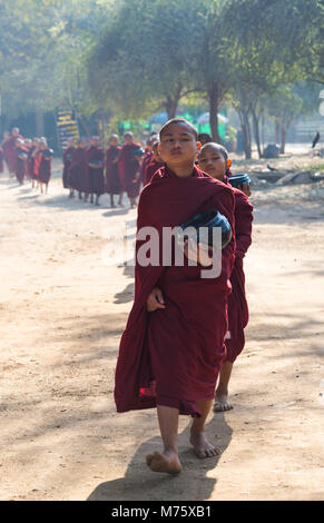 Processione di monaci buddisti che raccolgono elemosine a Bagan, Myanmar (Birmania), Asia in febbraio Foto Stock