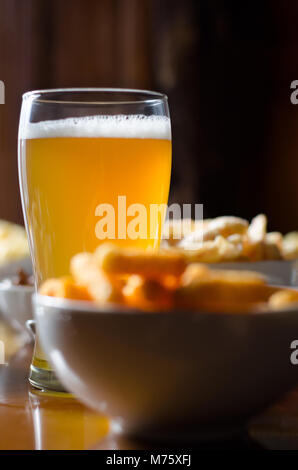 La pinta di birra chiara in un bicchiere, set di vari snack, un set standard di bere e di mangiare in un pub, birra e snack Foto Stock