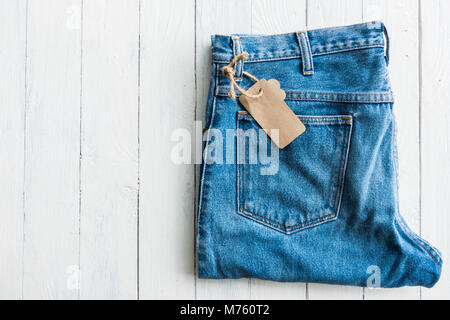 Close up denim pantaloni jeans mettere su bianco tavolo in legno Foto Stock