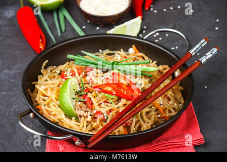 Amido di riso e patate) tagliatelle con manzo e verdure - peperoni, carote, zucchine, sesamo, calce, peperoncino e cipolla verde e salsa di soia. Un deliciou Foto Stock