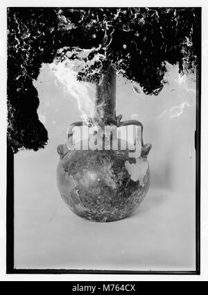 Questa immagine mostra un antico manufatto in vetro romano. Il vetro, datato all'antica epoca romana, mette in risalto l'artigianato e l'arte degli artigiani romani, riflettendo il significato culturale della lavorazione del vetro nell'antichità. Foto Stock