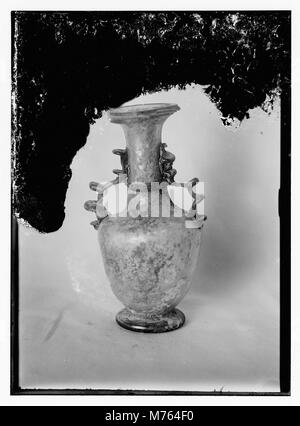 Questo pezzo di vetro antico romano mette in mostra l'intricata lavorazione artigianale di antichi vetrai. I manufatti in vetro romani sono noti per i loro disegni dettagliati e sono apprezzati per il loro significato storico. Foto Stock