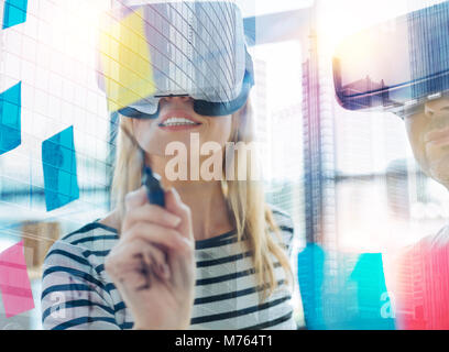 Curioso donna che indossa occhiali per realtà virtuale e tenendo un marcatore Foto Stock