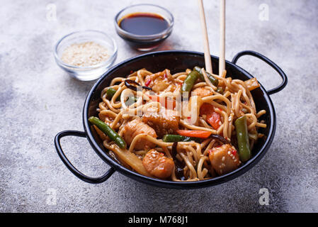 Friggere gli spaghetti con pollo, tofu e verdure. Foto Stock