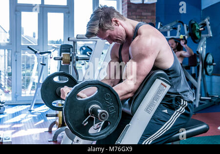 Muscolare di uomo che lavora fuori con pesi nella palestra Foto Stock