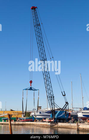 Grande barca gru o sollevare con un'imbracatura sulla banchina del porto di porto di pesca di Chioggia, Venezia, Veneto, Italia nel sud del lago veneziano Foto Stock