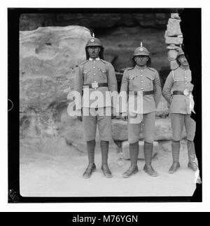 Un gruppo di soldati a Petra, un antico sito archeologico in Giordania, noto per la sua architettura scavata nella roccia e il sistema di condotti dell'acqua. Questa immagine cattura i soldati in un punto di riferimento storico. Foto Stock