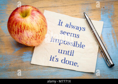 Sembra sempre impossibile fino a quando non si è fatto - scrittura su un tovagliolo con un apple. Foto Stock