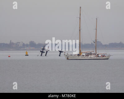 Sheerness, Kent, Regno Unito. 9 Marzo, 2018. Regno Unito Meteo: un nuvoloso con calma la mattina in Sheerness. Il Belgio twin masted yacht 'Zenobe grammo' (lunghezza: 29m) passa il relitto del SS Richard Montgomery nell'estuario del Tamigi. L'Addestramento alla vela di nave Zenobe grammo è stato originariamente concepito come una ricerca oceanografica nave da parte dell'architetto navale van Dijck e fu costruito nel 1961 presso l'ex Boel i cantieri di Temse, Belgio. Ella è chiamato dopo lo scienziato Zenobe grammo, l'inventore del primo dinamo industriale (1869). Credito: James Bell/Alamy Live News Foto Stock