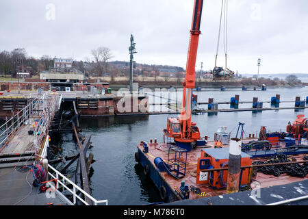 09 marzo 2018, Germania, Kiel: Il sito in costruzione al lato sud floodgate nel canale di Kiel sono segate in due con l aiuto di una fune sega. Una nave portacontainer si sono scontrate con il lato anteriore della paratoie il 19 febbraio 2018. Foto: Frank Molter/dpa Foto Stock