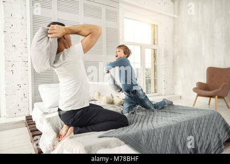 Ispirato a papà e figlio avente un cuscino lotta Foto Stock