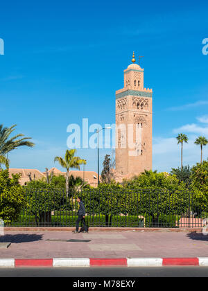 Marrakech, Marocco - 8 Dicembre 2016: un pedone in background della Moschea di Koutoubia (Kutubiyya Moschea) - la più grande moschea di Marrakech, Mo Foto Stock