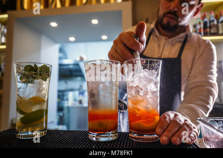 Il barista versa acqua frizzante in cocktail Foto Stock