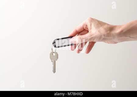 Donna mano che tiene una chiave di una casa con uno spazio bianco per scrivere in bianco e sfondi Foto Stock