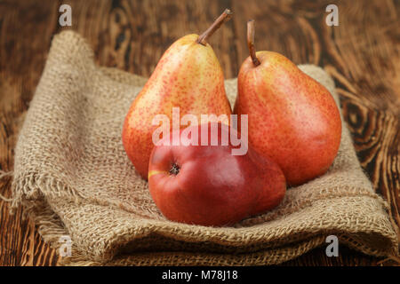 Ripe juicy rosso organico pere sul tavolo di legno. Messa a fuoco selettiva Foto Stock