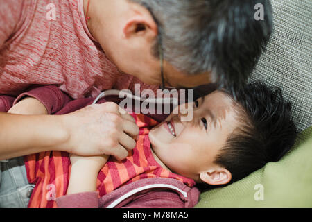 Immagine ravvicinata di un ragazzino essendo tickled da suo padre. Foto Stock