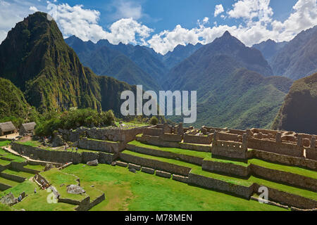 Persone turistiche in Machu Picchu passeggiate nel verde terrazze sulla soleggiata giornata di luce Foto Stock