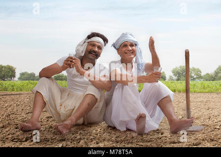 Due agricoltori seduta nel campo bere il tè Foto Stock