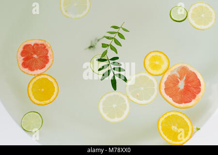 Latte acqua nella vasca da bagno, che nuotare citrus: lime, limone e pompelmo.La cura della pelle e del relax Foto Stock