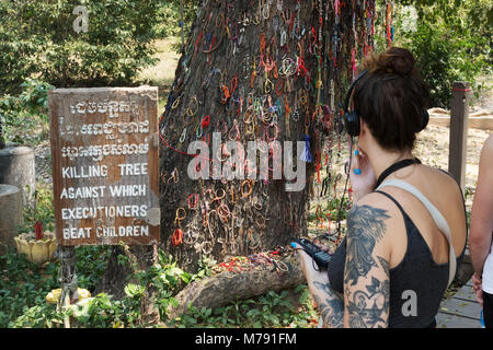 I turisti la visualizzazione della struttura ad albero di uccisione dei campi di sterminio, Choeung Ek genocidio Museo centro, Phnom Penh Cambogia Asia Foto Stock