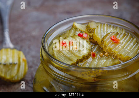 Fette di cetrioli sottaceto con pepe e senape in un vaso. Snack per i buongustai. Messa a fuoco selettiva Foto Stock