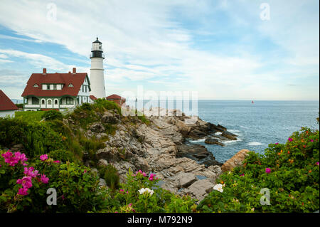 Portland Head Lighthouse circondata da rocce, sull'oceano e sulla spiaggia di rose in una calda giornata estiva nel Maine. Foto Stock