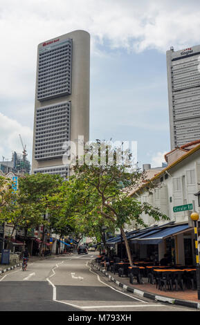 Viale alberato strada circolare e la sua fila di tradizionali botteghe in contrasto con i grattacieli del centro cittadino di Singapore. Foto Stock