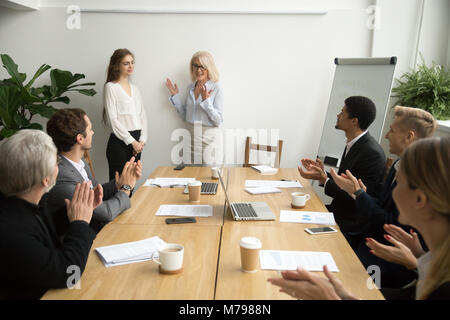 Senior boss donna introducendo nuovi lavoratore, team accogliente a soddisfare Foto Stock