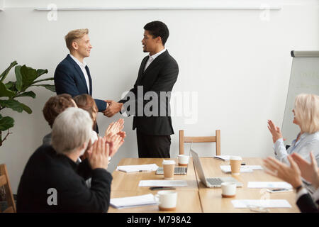 Ceo di nero e bianco imprenditore agitando mani alla riunione di gruppo Foto Stock
