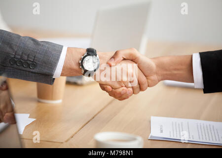Vista ingrandita di handshake, due imprenditori in giacca agitando la mano Foto Stock