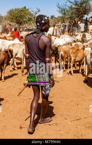 Giovani Hamar uomini Acquisto e vendita di bestiame al settimanale mercato tribale In Dimeka, Valle dell'Omo, Etiopia Foto Stock