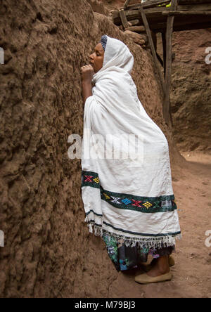 Donna che prega durante Kidane Mehret celebrazione ortodossa (st Mary cerimonia, il coperchio della misericordia), Amhara Region, Lalibela, Etiopia Foto Stock