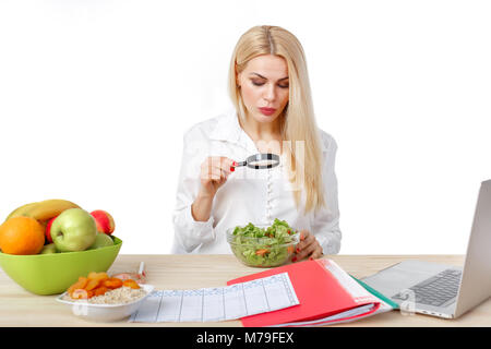 Dietista bella donna fare un programma di dieta e cercando in magnifier su insalata per una corretta alimentazione Foto Stock