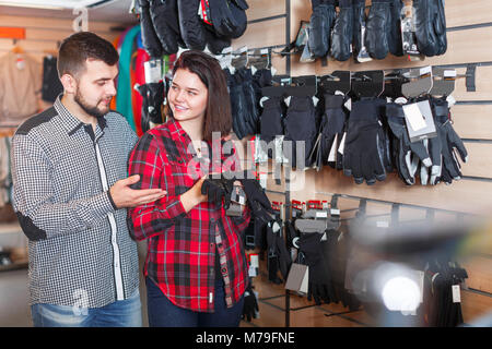 Paio di decidere su guanti protettivi per lo sport negozio di abbigliamento Foto Stock